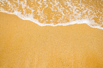 From above, behold the beauty of a sandy beach adorned with small, soothing waves. 