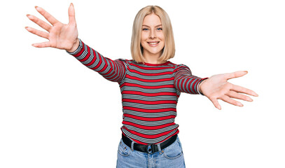 Young blonde woman wearing casual clothes looking at the camera smiling with open arms for hug....