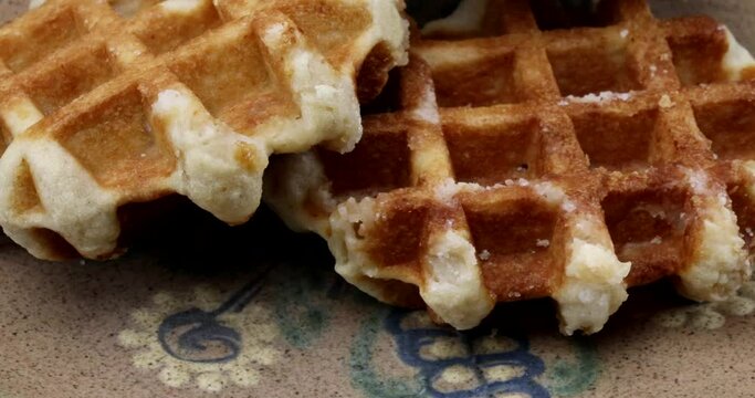 Video close-up of several sugar waffles on rotating breakfast plate