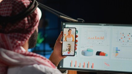 Islamic teleworker and coworkers in internet video call checking analytics statistical data sets. Arab employee optimizing key performance indicators in teleconference meeting, close up