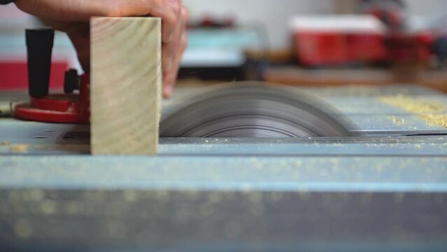 Shot of a man cutting a treated pine board and turning the table saw off