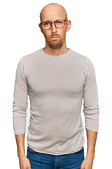 Fototapeta premium Bald man with beard wearing casual clothes and glasses skeptic and nervous, frowning upset because of problem. negative person.