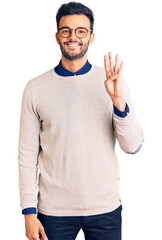 Fototapeta premium Young handsome hispanic man wearing elegant clothes and glasses showing and pointing up with fingers number four while smiling confident and happy.