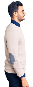 Young handsome hispanic man wearing elegant clothes and glasses looking to side, relax profile pose with natural face with confident smile.