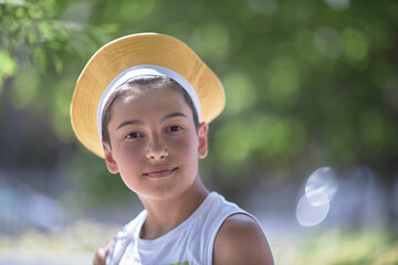 portrait of a child, a dark-haired boy of 10 years old in a summer cafe. Drinks a mojito and eats a hamburger