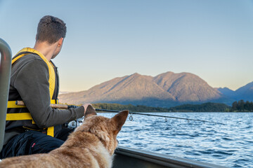 Picturesque image of a young man fishing from a boat with his dog, creating unforgettable memories...