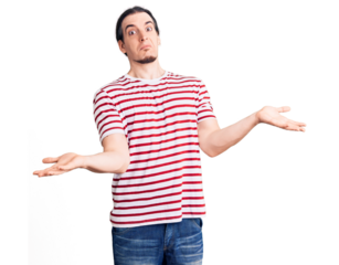 Young adult man with long hair wearing casual striped tshirt clueless and confused expression with arms and hands raised. doubt concept.