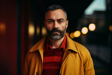 Portrait of a bearded man in a yellow raincoat in the city.