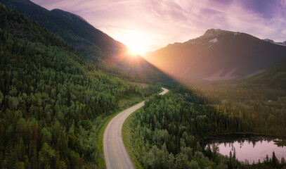 Scenic road in the valley surrounded by the Canadian Mountains. Aerial.