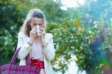stylish woman in dress and jacket in city has allergy attack