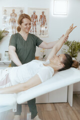 Obraz na płótnie Canvas smiling female therapist in massage cabinet doing checkup