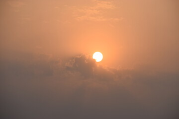 Golden Horizon: Sunset in Village with Clouds.This mesmerizing image captures the serene beauty of a village at sunset, where the sky is painted in warm hues, and clouds gracefully adorn the horizon.