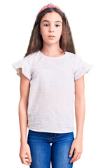 Obraz premium Cute hispanic child girl wearing casual white tshirt relaxed with serious expression on face. simple and natural looking at the camera.