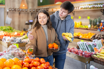 Obraz premium Happy married couple buying various fruits in a grocery supermarket