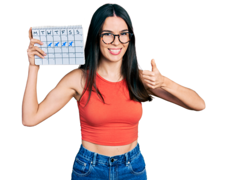 Young hispanic woman holding travel calendar smiling happy and positive, thumb up doing excellent and approval sign
