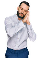 Young man with beard wearing business shirt sleeping tired dreaming and posing with hands together while smiling with closed eyes.