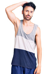 Fototapeta premium Young hispanic man wearing casual clothes confuse and wonder about question. uncertain with doubt, thinking with hand on head. pensive concept.