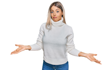 Beautiful blonde woman wearing casual turtleneck sweater clueless and confused expression with arms and hands raised. doubt concept.