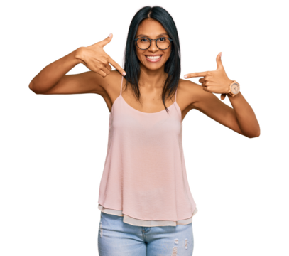 Young african american woman wearing casual clothes and glasses looking confident with smile on face, pointing oneself with fingers proud and happy.
