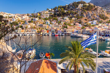 Multi-colored facades of houses in the village of Symi at sunset.