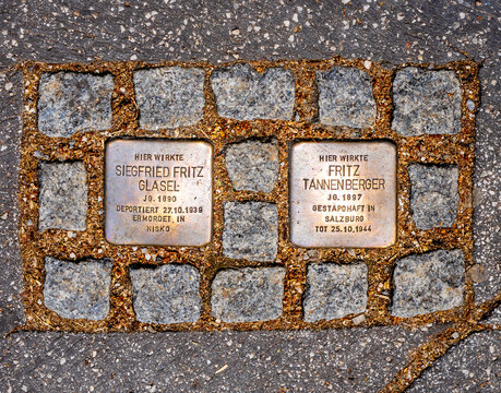 Salzburg, AT – June 7, 2023 Landscape view of two Stolpersteins or 'stumbling stones', a brass plate inscribed with the name and life dates of victims of Nazi extermination or persecution.