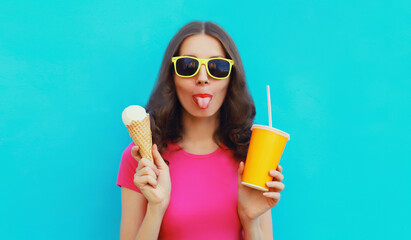Summer portrait of happy young woman eating ice cream and holding cup of fresh juice wearing...