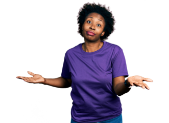 African american woman with afro hair wearing casual purple t shirt clueless and confused expression with arms and hands raised. doubt concept.