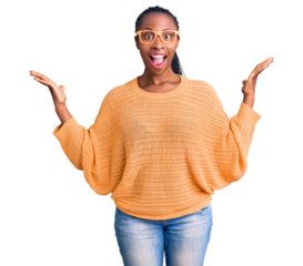 Young african american woman wearing casual clothes and glasses celebrating victory with happy smile and winner expression with raised hands