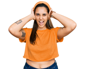 Young hispanic woman wearing casual clothes crazy and scared with hands on head, afraid and surprised of shock with open mouth