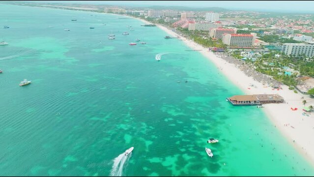 Eaglebeach Aruba droneshot with speedboat over blue water 