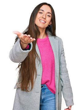 Young hispanic girl wearing business clothes smiling friendly offering handshake as greeting and welcoming. successful business.
