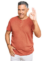 Handsome middle age man wearing casual clothes smiling positive doing ok sign with hand and...
