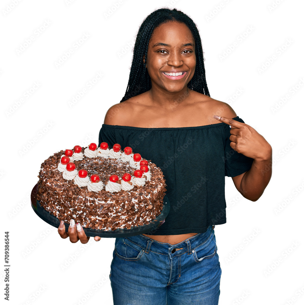 Canvas Prints Young african american woman celebrating birthday holding big chocolate cake pointing finger to one self smiling happy and proud