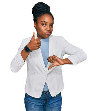 Young african american woman wearing business clothes doing thumbs up and down, disagreement and agreement expression. crazy conflict