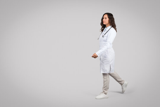 Female Doctor Walking Confidently In White Coat, Free Space