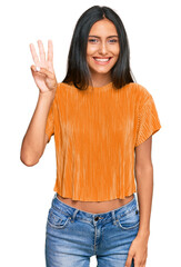 Young brunette arab woman wearing casual clothes showing and pointing up with fingers number three while smiling confident and happy.