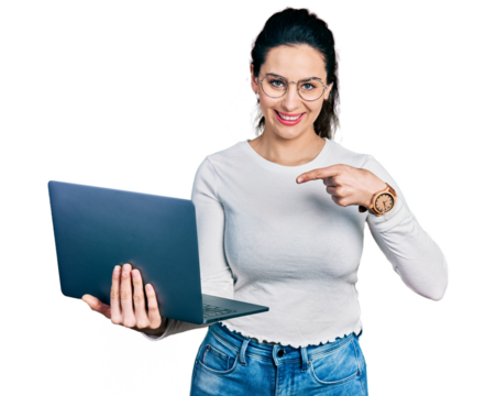 Young hispanic woman working using computer laptop smiling happy pointing with hand and finger