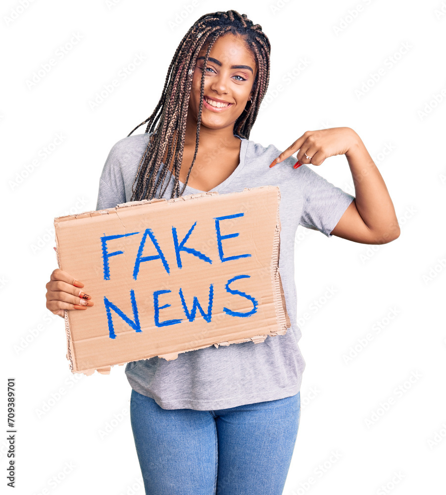 Poster Young african american woman with braids holding fake news banner pointing finger to one self smiling happy and proud