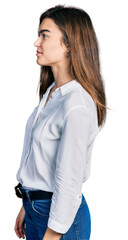 Fototapeta premium Young caucasian girl wearing casual white shirt looking to side, relax profile pose with natural face and confident smile.