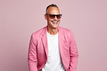 Portrait of a happy mature man in sunglasses and pink jacket.