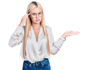 Beautiful blonde woman wearing elegant shirt and glasses confused and annoyed with open palm showing copy space and pointing finger to forehead. think about it.