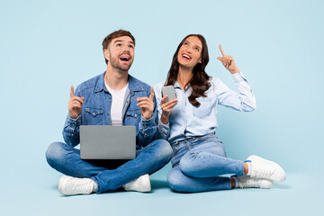Excited couple with laptop and phone, having an eureka moment