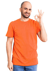 Young handsome man wering casual t shirt smiling positive doing ok sign with hand and fingers. successful expression.