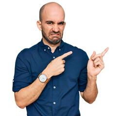 Young hispanic man wearing casual clothes pointing aside worried and nervous with both hands,...