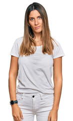 Fototapeta premium Young woman wearing casual white t shirt with serious expression on face. simple and natural looking at the camera.
