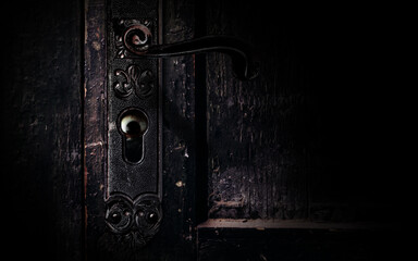 Photo of old obsolete and shaded abandoned grungy door handle with horror scary eye peaking from...