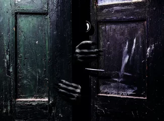 Papier Peint photo autocollant Vielles portes Photo of old obsolete and shaded abandoned grungy door with scary female monster hands with claws reaching out from darkness.