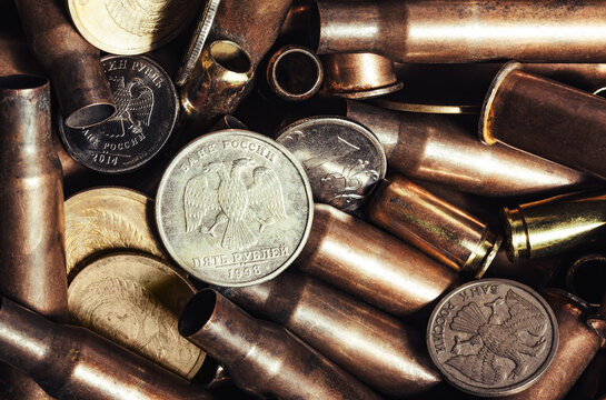 Photo of Russian coins laying on bullet shells, close up view.