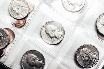 Photo of USA quarter coins in plastic holder sheet, close up view.