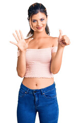 Young beautiful woman wearing casual clothes showing and pointing up with fingers number six while smiling confident and happy.